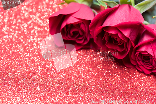 Image of Roses over red abstract background with bokeh