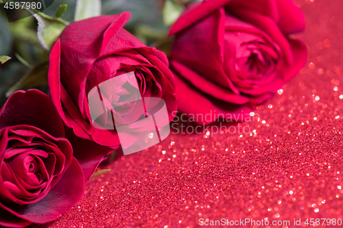 Image of Roses over red abstract background with bokeh