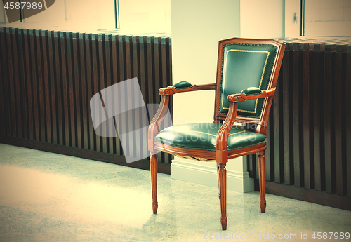 Image of chair with a leather green seat, back, and armrests