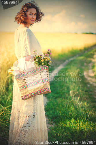 Image of woman in white dress with basket with bread and milk walking alo