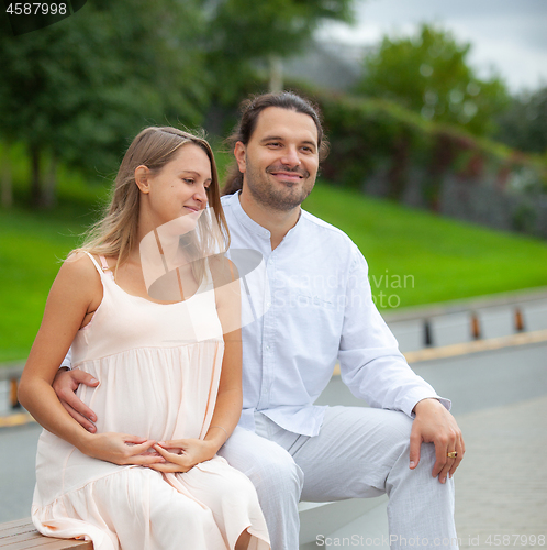 Image of Pregnant woman and young father outdoor