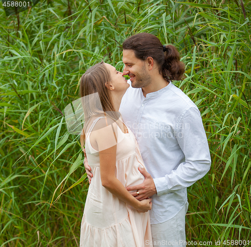 Image of  A man and a pregnant woman in a park