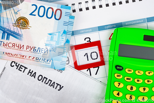 Image of The calendar is allocated the number 10, there is a bill for payment, money and calculator