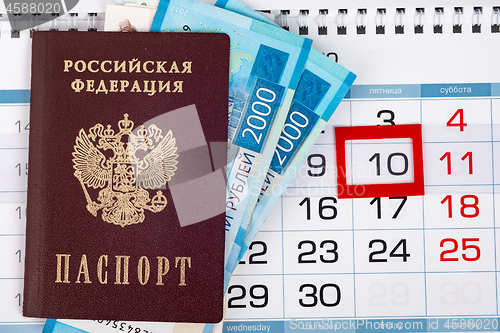 Image of View from above on the calendar on which lies a passport with 2,000 ruble banknotes