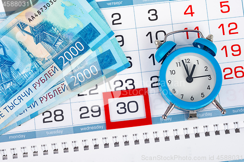 Image of Calendar with a dedicated 30 number, a pack of Russian money and a clock