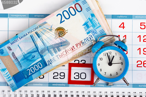 Image of Calendar with a dedicated 30 number, a big pack of Russian money and a clock