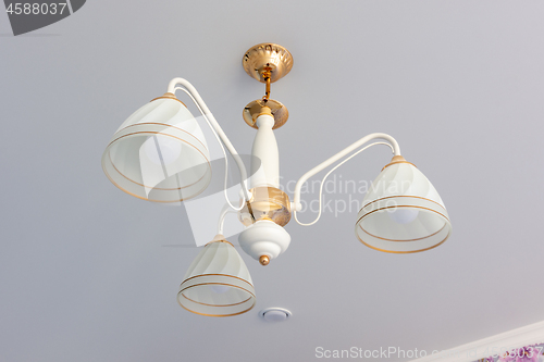 Image of A chandelier on the ceiling with snare ceilings, close-up