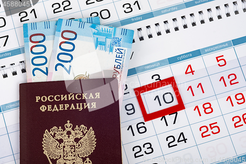 Image of Russian passport with banknotes two thousand rubles are on the calendar with a dedicated date tenth number