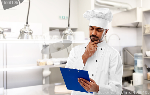 Image of indian chef with clipboard at restaurant kitchen