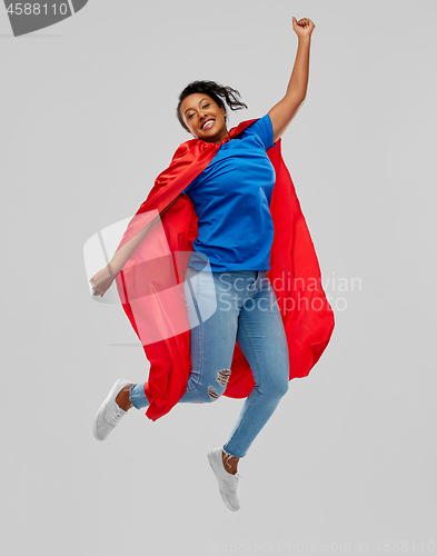 Image of happy african american woman in superhero red cape