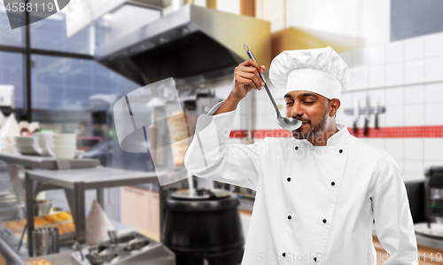 Image of indian chef tasting food from ladle at kebab shop