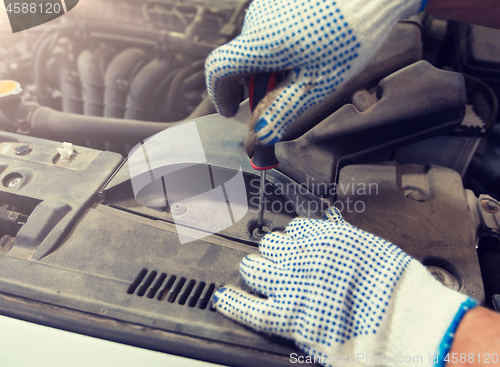 Image of mechanic man with wrench repairing car at workshop