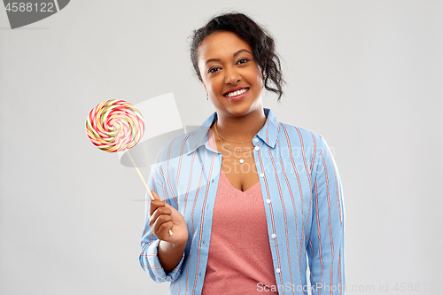 Image of happy african american woman with big lollipop