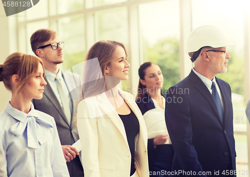 Image of business team in helmets walking along office