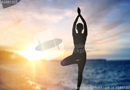 Image of silhouette of woman making yoga over sea sunset