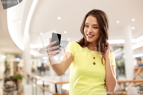 Image of teenage girl taking selfie in shopping mall