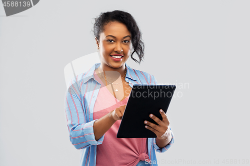 Image of happy african american woman using tablet pc