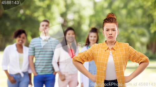 Image of displeased redhead teenage girl with hands on hips