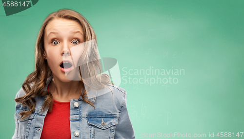 Image of surprised student girl over green background