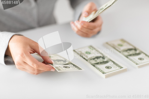 Image of close up of woman hands counting us dollar money