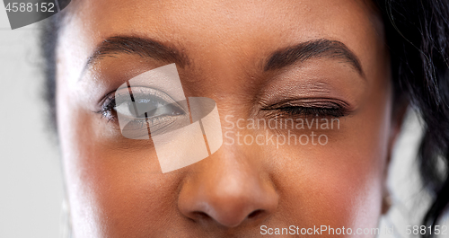 Image of close up of african american woman winking one eye
