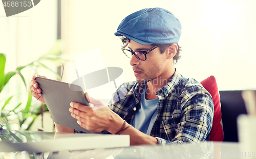 Image of man with tablet pc sitting at cafe table