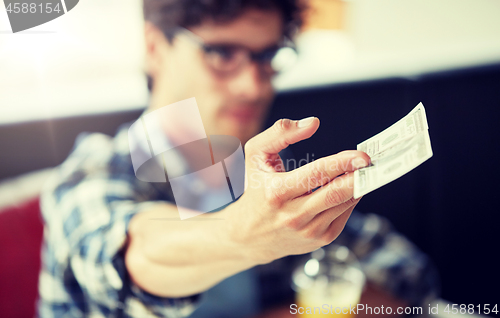 Image of man with cash money paying at cafe