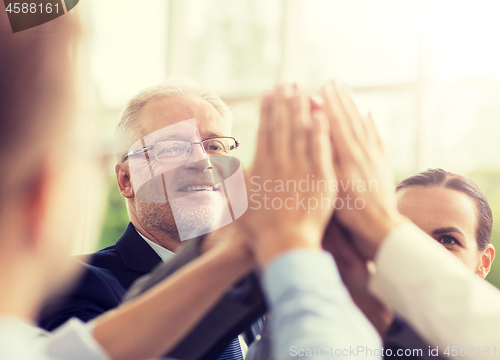 Image of business people making high five in office