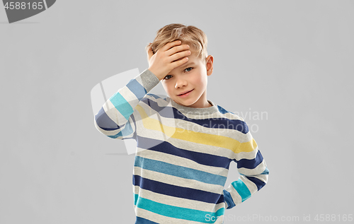 Image of sick boy in red t-shirt suffering from headache