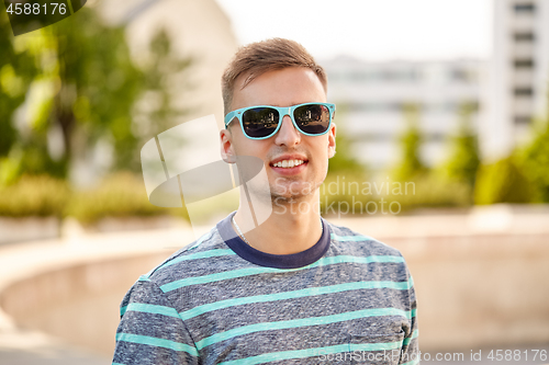 Image of portrait of young man in sunglasses at summer city