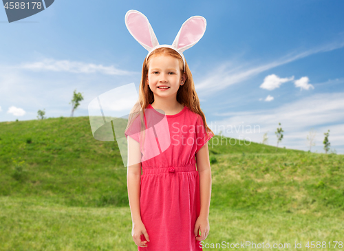 Image of happy red haired girl wearing easter bunny ears