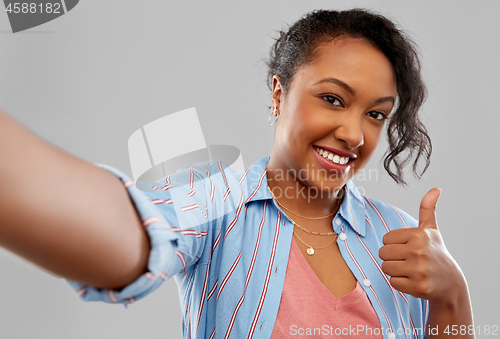 Image of happy african american woman taking selfie