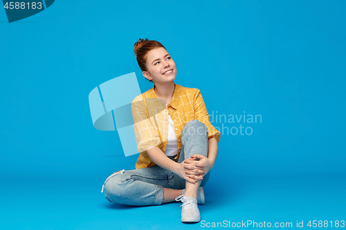 Image of red haired teenage girl in shirt and torn jeans