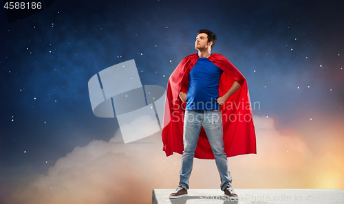 Image of man in red superhero cape over night sky