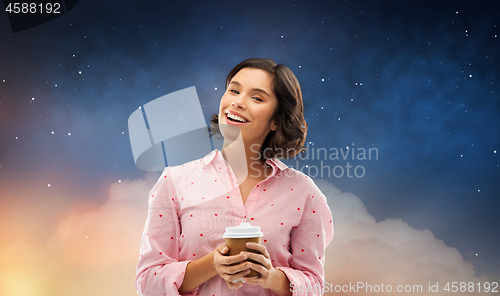 Image of happy young woman in pajama with cup of coffee