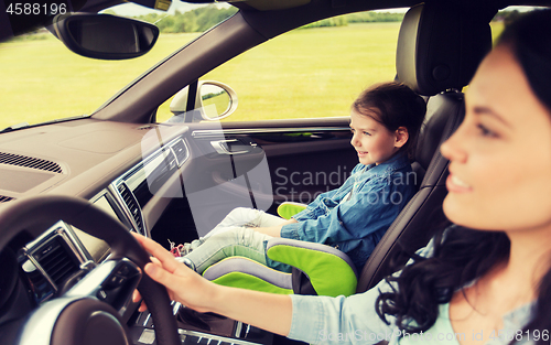 Image of happy woman with little girl driving in car