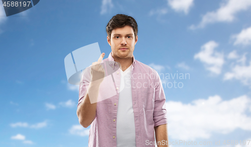 Image of young man over blue sky and clouds background