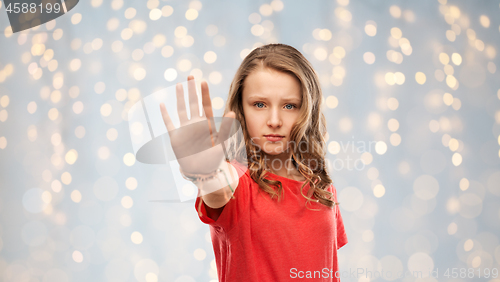 Image of serious teenage girl showing stop gesture