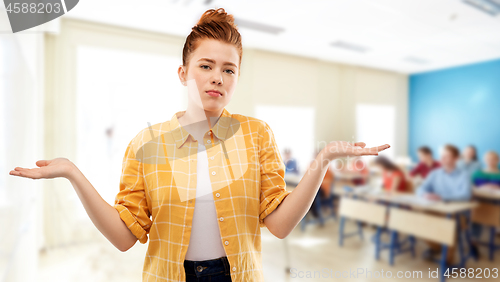 Image of sad red haired student girl shrugging at school