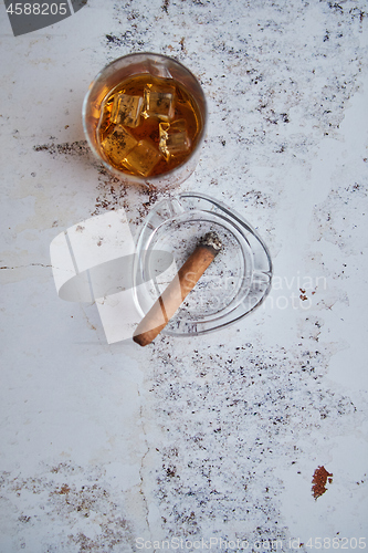 Image of Whiskey or brandy in a glass with Cuban cigar