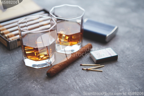 Image of Carafe of Whiskey or brandy, glasses and box of finnest Cuban cigars