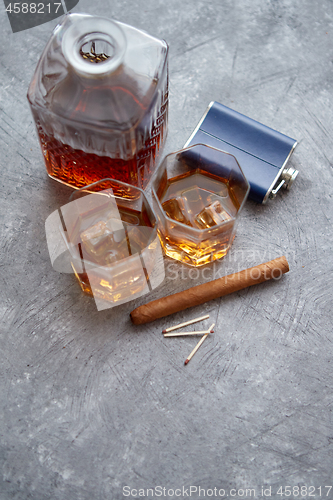 Image of Two glasses of old whiskey with cuban cigar and carafe