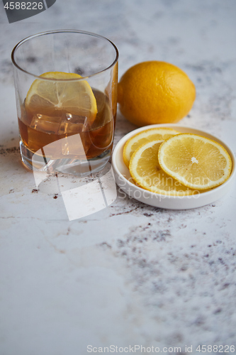 Image of Whiskey sour drink with lemon in glass on stone rustical background