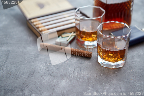 Image of Carafe of Whiskey or brandy, glasses and box of finnest Cuban cigars