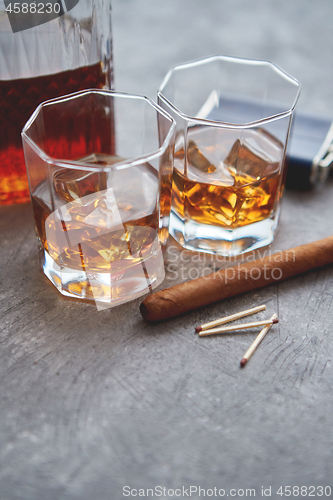 Image of Two glasses of old whiskey with cuban cigar and carafe