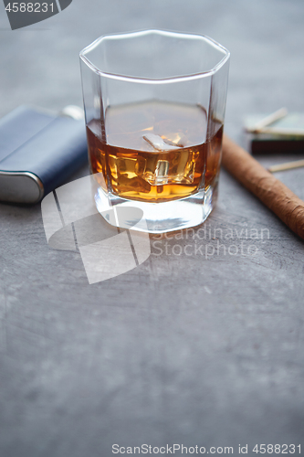 Image of Glass of whiskey with ice, big cuban cigar, matches and hip flask