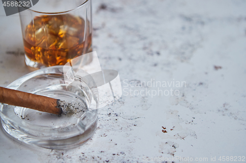 Image of Whiskey or brandy in a glass with Cuban cigar