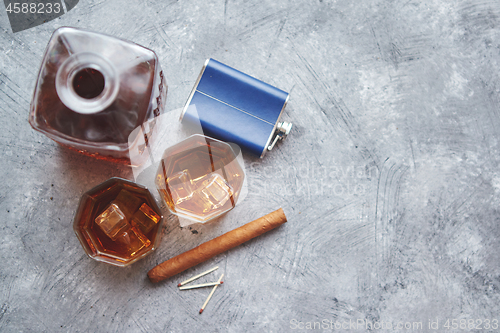 Image of Two glasses of old whiskey with cuban cigar and carafe