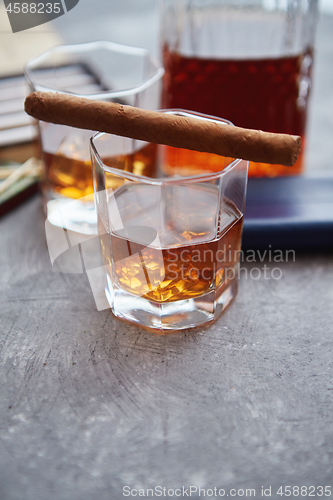 Image of Carafe of Whiskey or brandy, glasses and box of finnest Cuban cigars