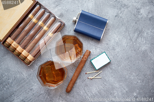 Image of Carafe of Whiskey or brandy, glasses and box of finnest Cuban cigars